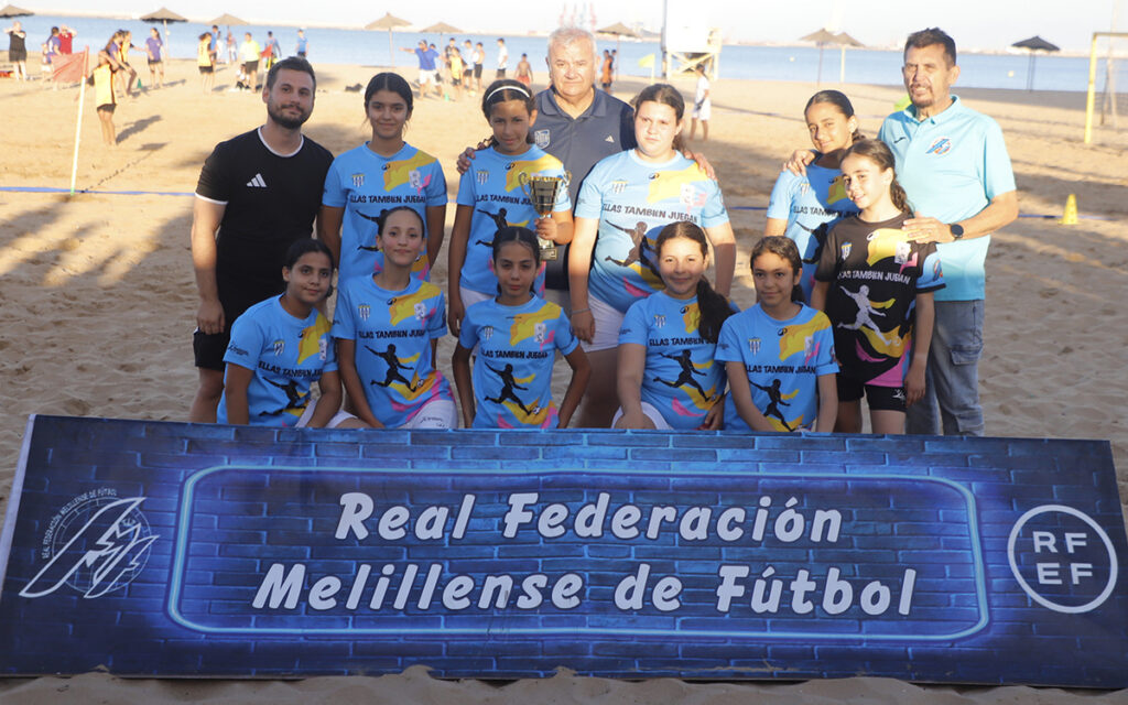 Equipo de fútbol femenino subcampeón con trofeo en la playa