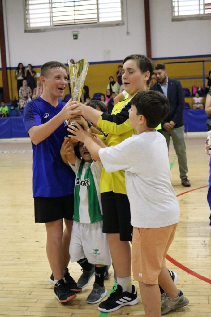 Niños celebrando con un trofeo en el Pabellón Municipal Lázaro Fernández