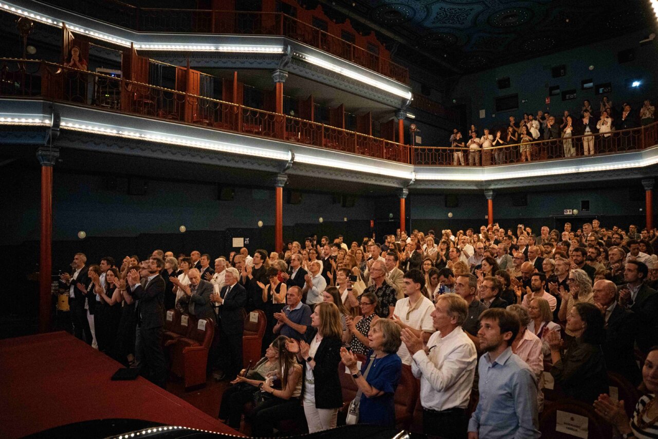 Multitud aplaudiendo en el Cine Dore durante un evento
