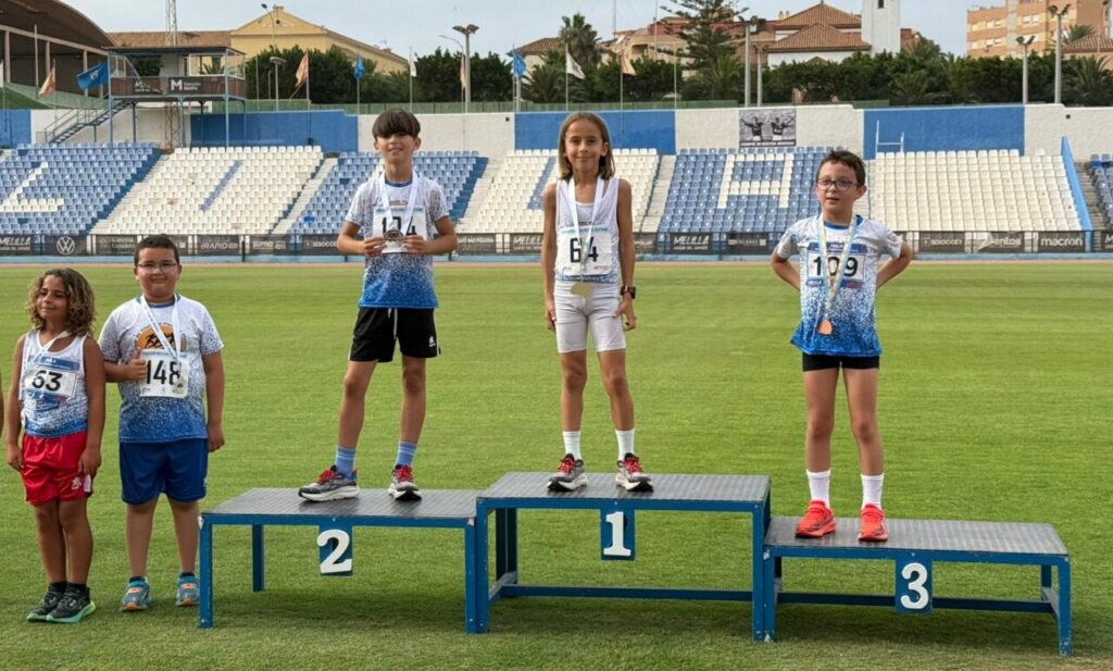Atletas jóvenes en el podio tras una competición de medio fondo