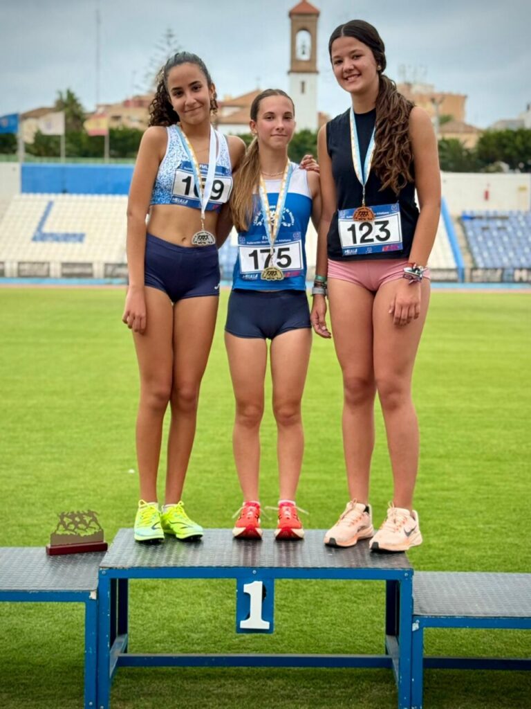 Tres jóvenes atletas en el podio tras una competición de medio fondo