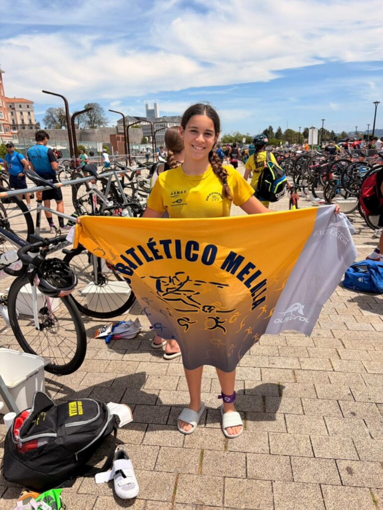 Joven triatleta del Club Atlético Melilla con bandera en evento deportivo