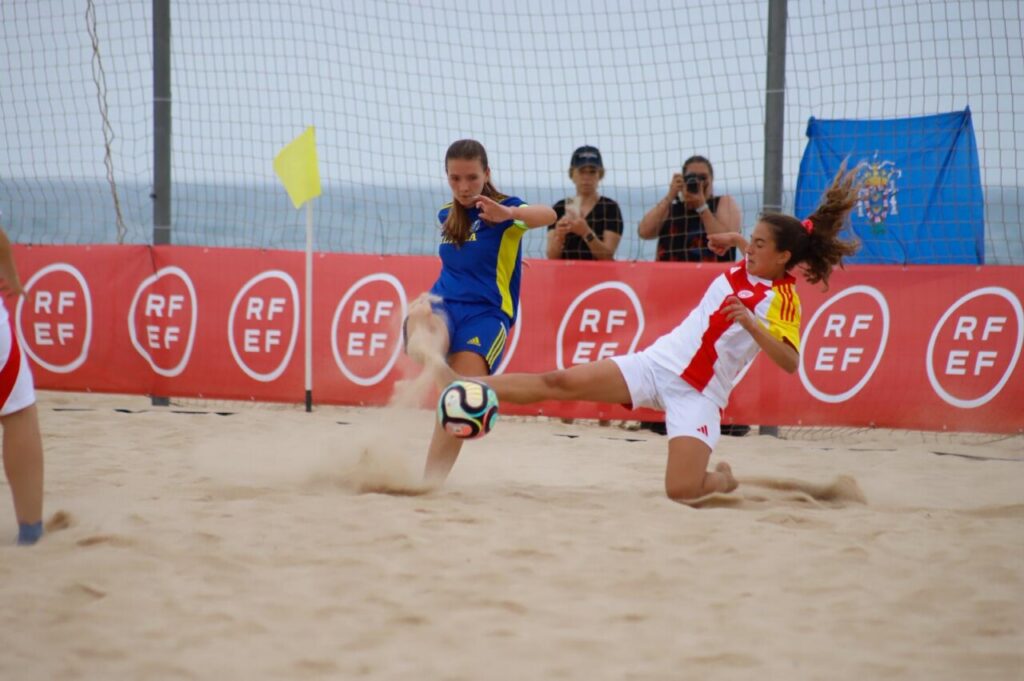 Jugadoras compitiendo en un partido de fútbol playa femenino en Rota.