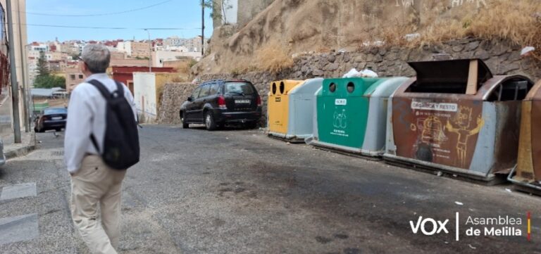 Persona caminando por el Barrio Hebreo con contenedores de residuos