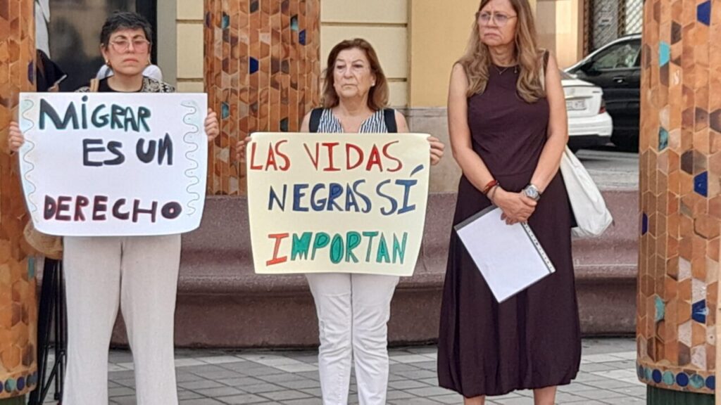 Tres mujeres sosteniendo pancartas en un acto de protesta en Melilla