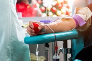 Persona donando sangre en un centro de salud con un balón en la mano.