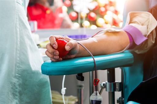 Persona donando sangre en un centro de salud con un balón en la mano.