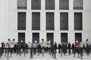 Personas en fila esperando para la regularización de migrantes en España