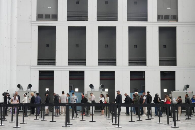 Personas en fila esperando para la regularización de migrantes en España