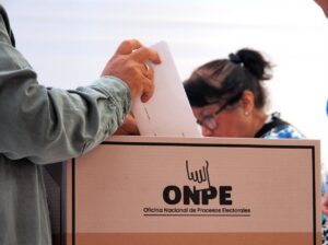 Persona depositando un voto en una urna electoral de la ONPE en Perú