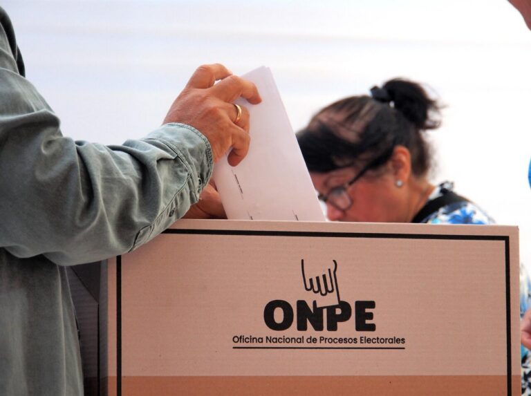 Persona depositando un voto en una urna electoral de la ONPE en Perú