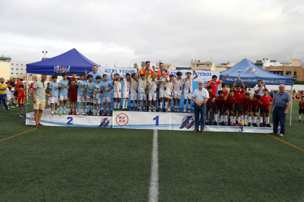Niños celebrando la entrega de trofeos en un torneo de fútbol infantil