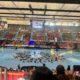 Vista del pabellón lleno durante un evento deportivo con actuaciones en el suelo.