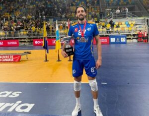 Fede Martina sosteniendo un trofeo en la cancha de voleibol