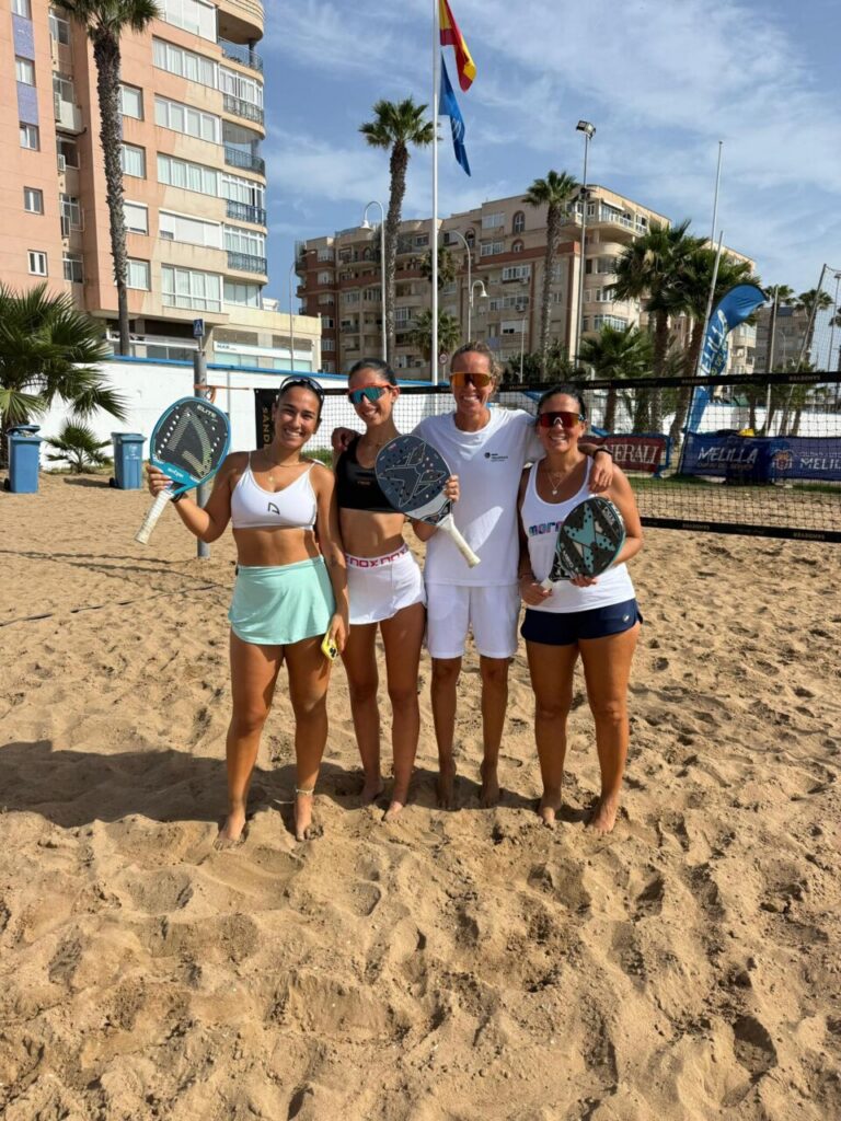 Jugadoras de tenis playa posando con palas en la playa de Melilla