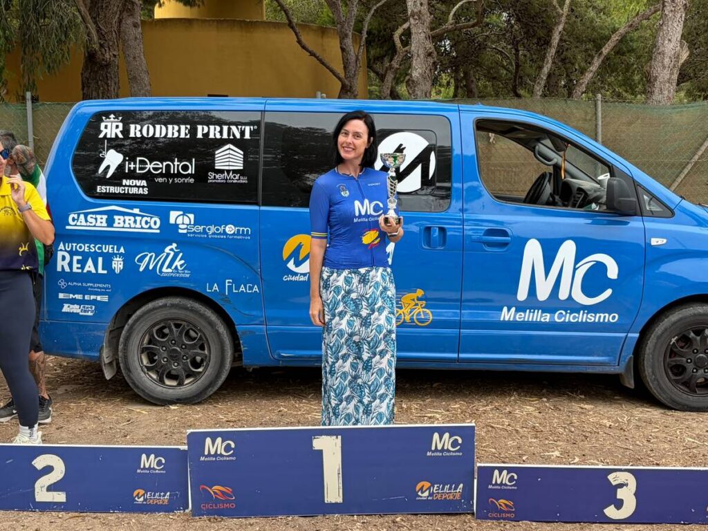 Mujer ganadora en el VI GP XCO con trofeo en mano