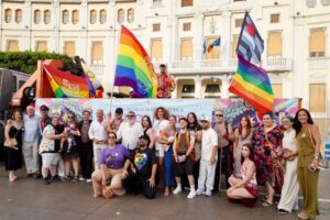 Grupo de personas celebrando el Orgullo en la marcha con banderas de colores