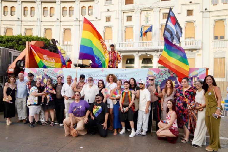 Grupo de personas celebrando el Orgullo en la marcha con banderas de colores