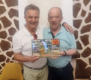 Dos hombres sosteniendo un álbum de fotos en un homenaje emotivo
