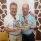 Dos hombres sosteniendo un álbum de fotos en un homenaje emotivo