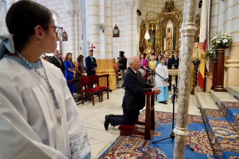 Juan José Imbroda arrodillado ante la Virgen de la Victoria en una ceremonia