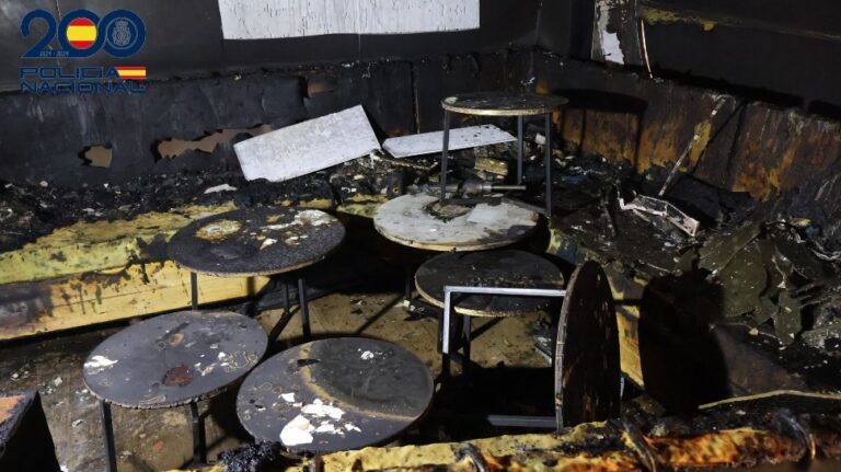 Restaurante dañado por incendio con mesas y sillas quemadas