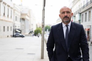 Jaime de los Santos en una calle de la ciudad con traje formal.