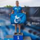 Jesús Herrero en el podio con medalla de oro y bandera del Club Natación Melilla