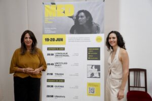 Presentación del festival Melilla en Danza con dos mujeres sonriendo frente a un cartel.