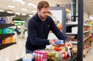 Cliente en supermercado Mercadona seleccionando productos saludables