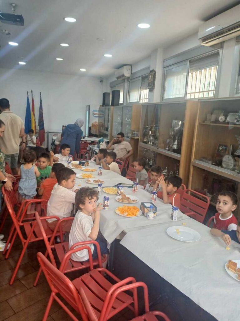 Niños disfrutando de una merienda en la Escuela Luisca