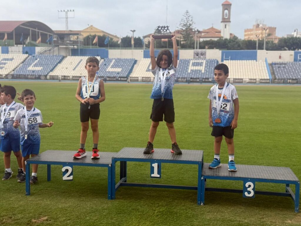 Jóvenes atletas en el podio tras competir en el mitin de medio fondo