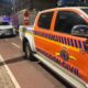 Emergency civil protection vehicle parked on a city street at night, orange and white with blue stripes and crest reading 'Protección Civil'