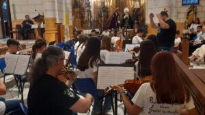 Músicos de la Orquesta Joven Ciudad de Melilla tocando en un concierto