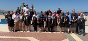 Grupo de personas en la playa con delantales en evento gastronómico