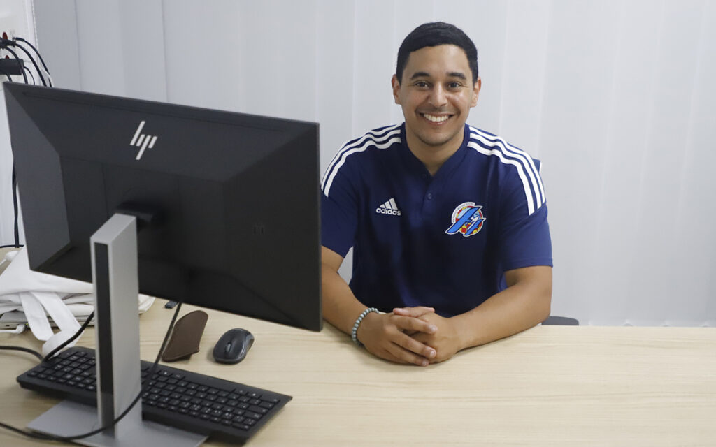 Imad Ansar Mohamed, podólogo deportivo en su oficina, sonriente.