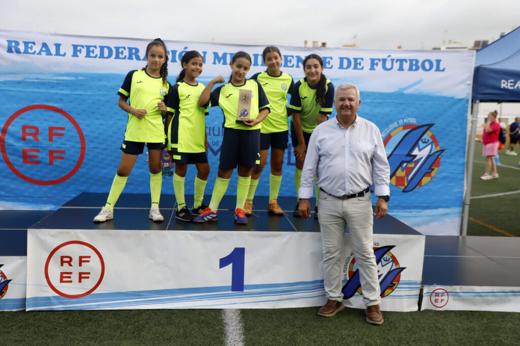 Niñas posando con trofeo en premiación de fútbol infantil