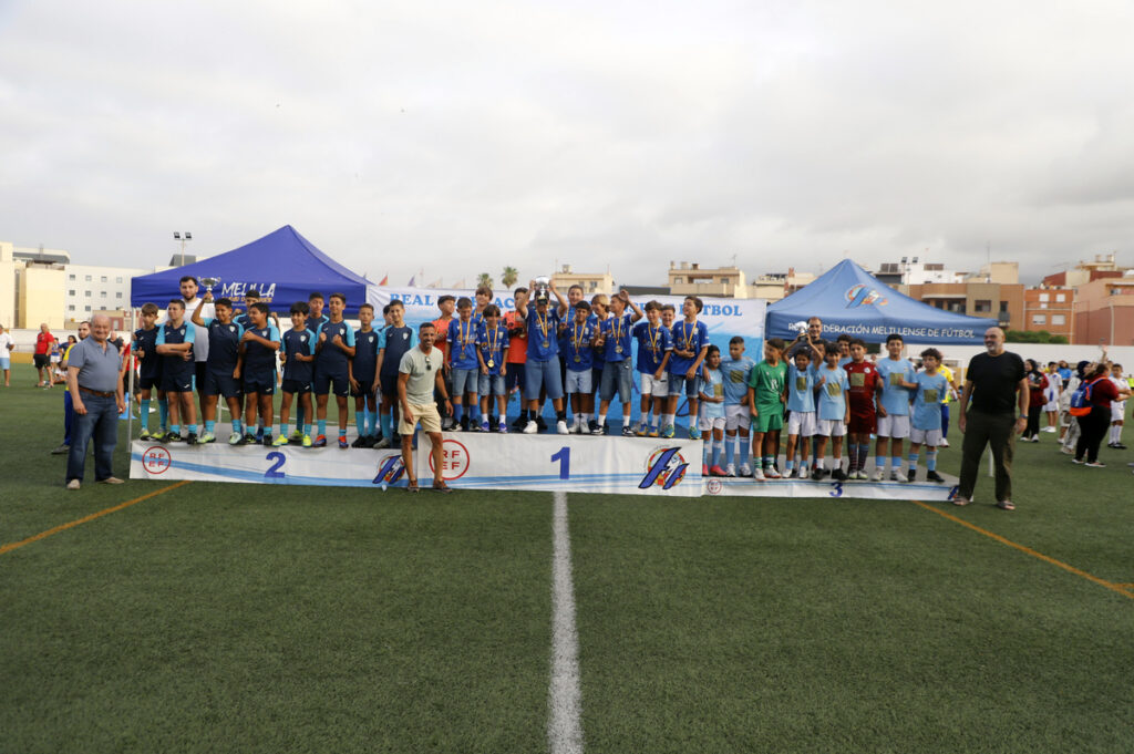 Equipo de fútbol en ceremonia de premiación con trofeos y medallas