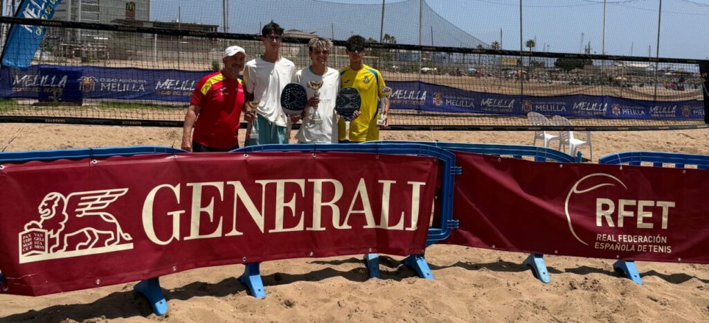 Four players on a sandy beach tennis court pose with trophies behind a red Generali banner and RFET signs on the barrier.