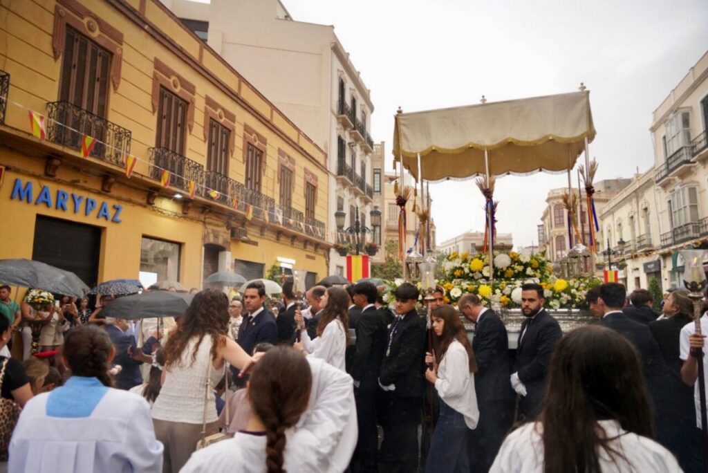 Procesión de Corpus Christi en Melilla con participantes bajo la lluvia