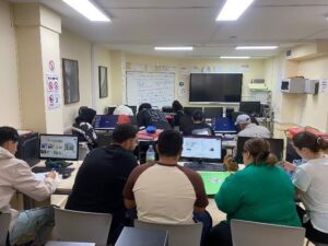 Clase de adultos en un aula con computadoras trabajando en su formación