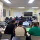Clase de adultos en un aula con computadoras trabajando en su formación