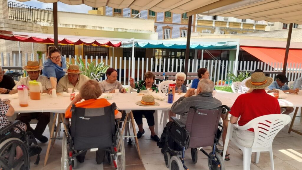 Residentes del Centro Asistencial disfrutando de una comida con paella y gambas