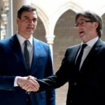 Sánchez y Puigdemont estrechando manos en un encuentro político