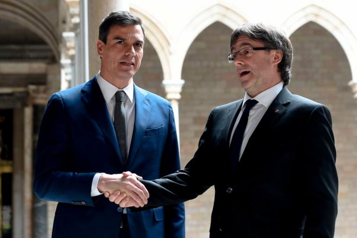 Sánchez y Puigdemont estrechando manos en un encuentro político