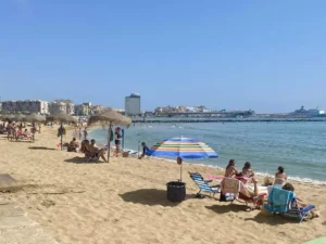 Personas disfrutando de la playa en Melilla con sombrillas y sillas
