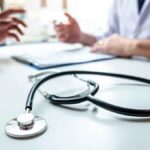 Consulta médica con un estetoscopio en la mesa y manos gesticulando
