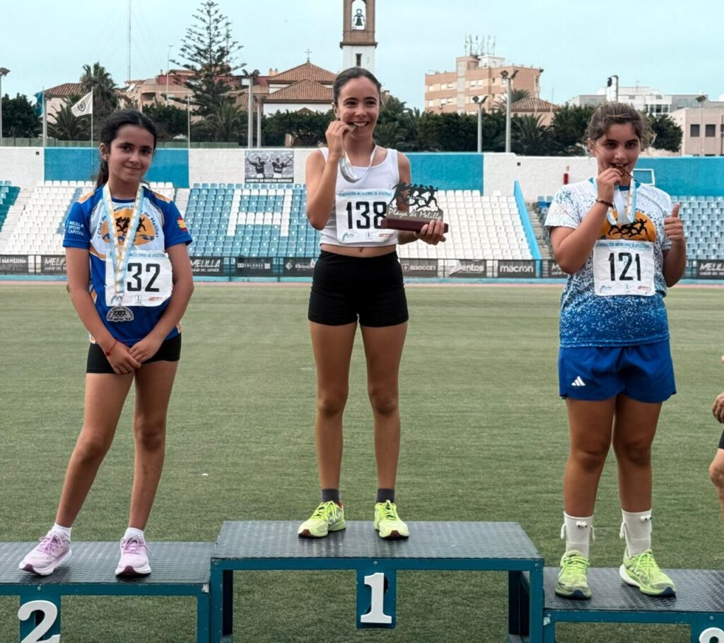 Tres jóvenes atletas en el podio tras una competición de medio fondo