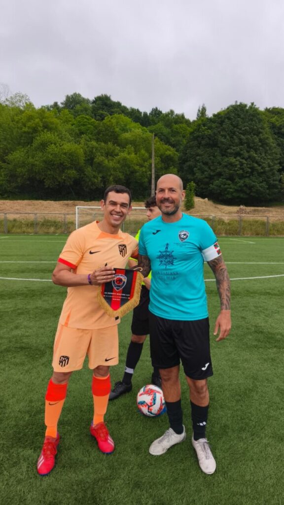 Jugadores de fútbol sosteniendo un trofeo en el campo