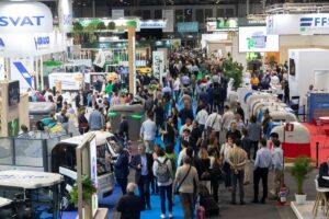 Multitud de personas en la feria TECMA 2026 con stands y vehículos